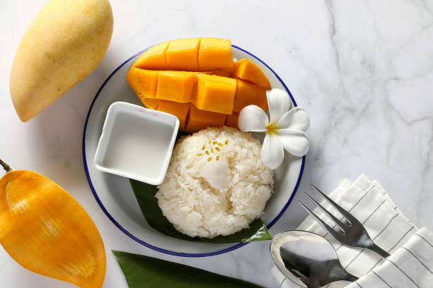 Mango sticky rice with coconut milk in the white plate on white table background. Famous Popular Dessert in Thailand. stock photo