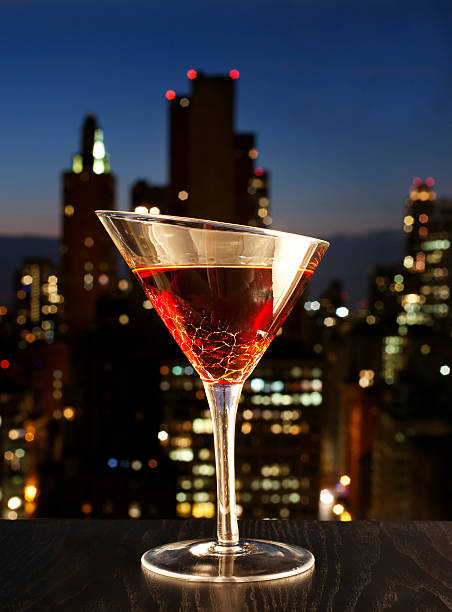 Manhatan cocktail Manhatan cocktail with Manhatan skyline at background. manhattan cocktail stock pictures, royalty-free photos & images