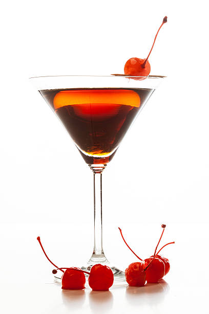 Manhattan cocktail garnished with a cherry Manhattan cocktail garnished with a cherry on white background manhattan cocktail stock pictures, royalty-free photos & images