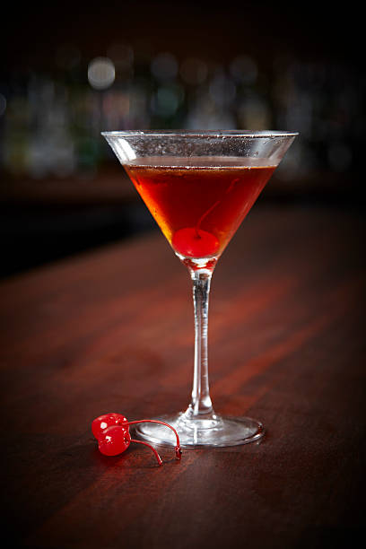 A Manhattan cocktail with cocktail cherries Manhattan On A Bar Couter manhattan cocktail stock pictures, royalty-free photos & images
