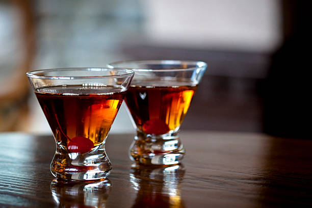 Manhattan cocktails Two Manhattan cocktails on wooden table. vermouth stock pictures, royalty-free photos & images