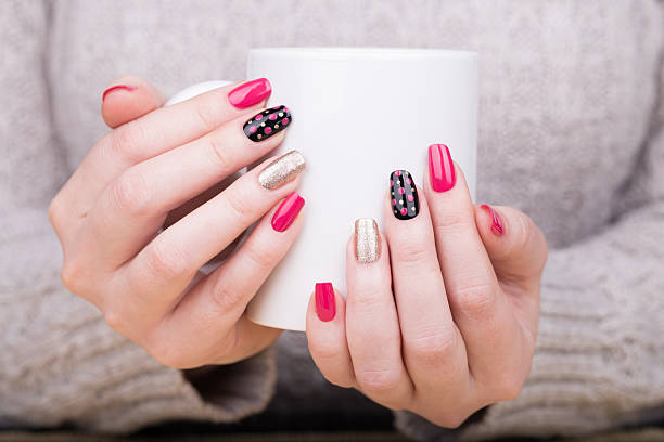 Manicure Beauty treatment photo of nice manicured woman fingernails. Very nice feminine nail art with nice pink, gold and black nail polish. artificial nail stock pictures, royalty-free photos & images