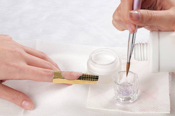 Manicure-acrylic nail Manicurist treating customer's nails at the beauty salon.Manicure treatment artificial nail stock pictures, royalty-free photos & images
