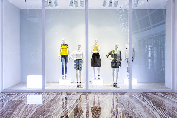 mannequins in fashion shop display window - etalage stockfoto's en -beelden