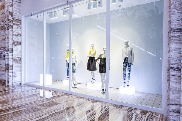 mannequins in fashion shop display window - etalage stockfoto's en -beelden