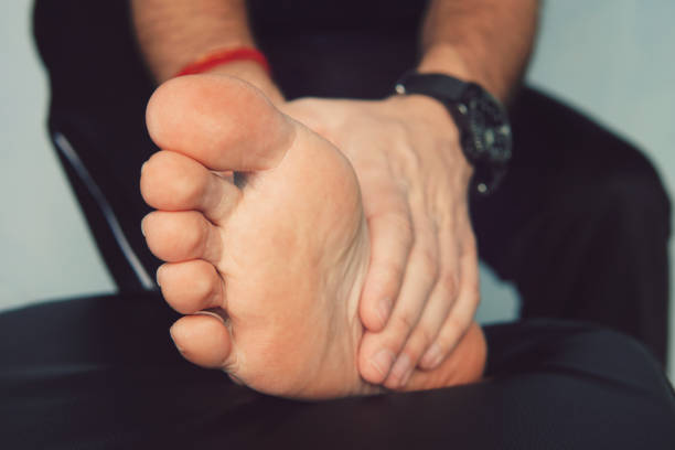 Man's hand being massaged a foot, Man with painful and inflamed gout on his foot around the big toe area. Man's hand being massaged a foot, Man with painful and inflamed gout on his foot around the big toe area. foot anatomy stock pictures, royalty-free photos & images