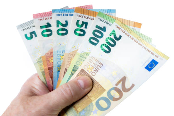 man's hand is holding a series of euro banknotes against a white background stock photo