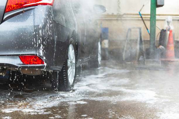 Manual car wash with white soap, foam on the body. Washing Car Using High Pressure Water. stock photo