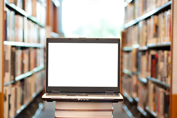 Many books and laptop in library - horizontal stock photo