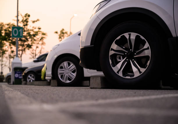 Many cars are parked in a large parking lot. Arranged in a long line Was the time when the sun was setting stock photo