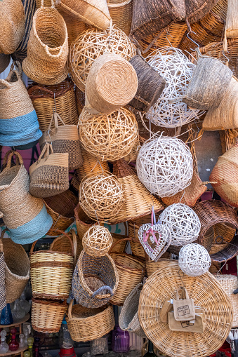 Handmade wicker round and various shaped baskets with different textures displayed for sale. Traditional handcrafted manufacture. Grand Bazaar. Assorted variety of home storage organizers, Straw lampshade and female handbags.