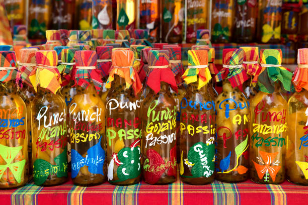 Many different colored punch(rum and tropical fruits) bottles in a row on a typical market, Guadeloupe, French West Indies. Many different colored punch(rum and tropical fruits) bottles in a row on a typical market, Guadeloupe, French West Indies. antilles stock pictures, royalty-free photos & images