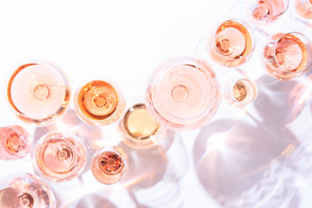 Many glasses of rose wine at wine tasting. Concept of rose wine and variety Many glasses of rose wine at wine tasting. Concept of rose wine and variety. White background. Top view, flat lay design. Direct sunlight. Toned image. alcohol drink photos stock pictures, royalty-free photos & images