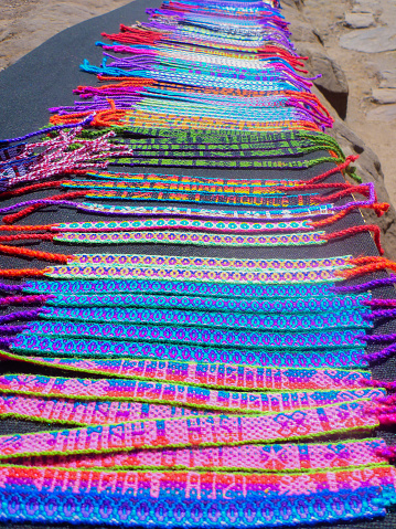 Many handmade bracelets lined up as souvenirs in Peru