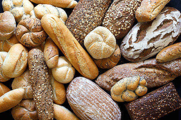 Many mixed breads and rolls shot from above. Many mixed breads and rolls shot from above. baguette photos stock pictures, royalty-free photos & images