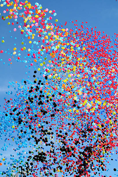 Many multi colored party balloons against the blue sky. Celebration. stock photo