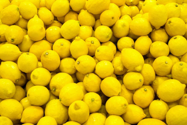 many of fresh lemons closeup wallpaper many of fresh lemons closeup background lemon fruit stock pictures, royalty-free photos & images