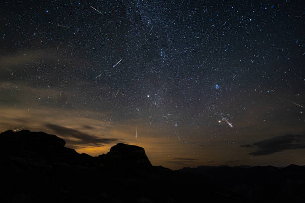 many stars, milky way and perseids on night sky in the mountains stock photo