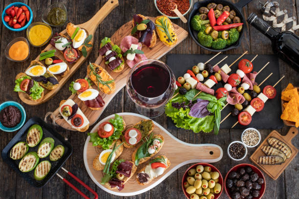 Many tapas on the rustic wooden table with black background. Top view mediterian food concept. tapas stock pictures, royalty-free photos & images