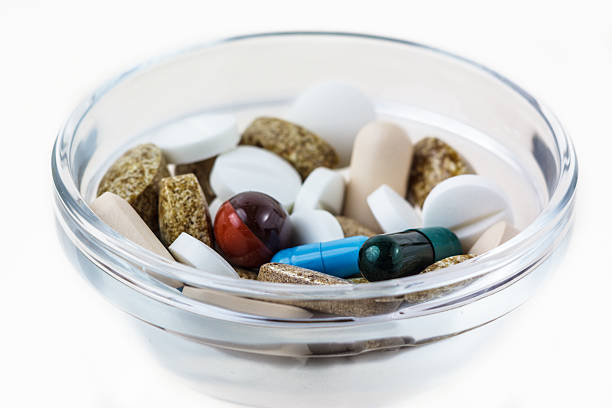 Many various pills in glass bowl stock photo