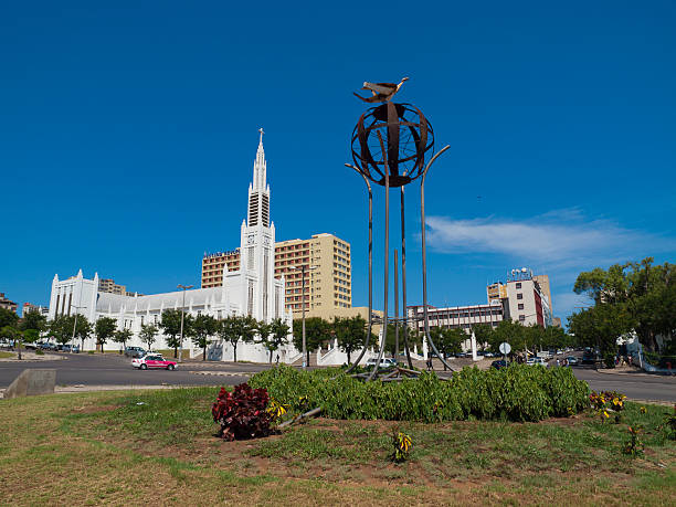 Maputo Landmark, Mozamique Maputo, Mozambique - December 21, 2009: Strange monument in Maputo, with the Cathedral of Our Lady of the Immaculate Conception and the Pestana Rovuma hotel building in the background.People can be seen walking along the sidewalk in the foreground. maputo city stock pictures, royalty-free photos & images