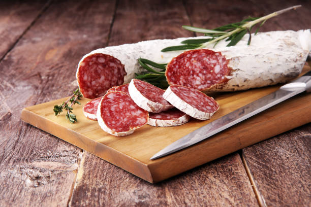 Marble cutting board with sliced salami on it. stock photo