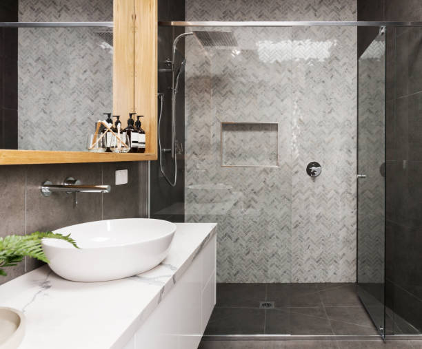 Marble mosaic herringbone tiled shower feature wall in a contemporary ensuite bathroom stock photo