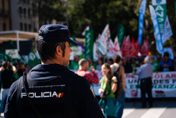 March for education. Strike. Policeman in foreground, people in the background stock photo