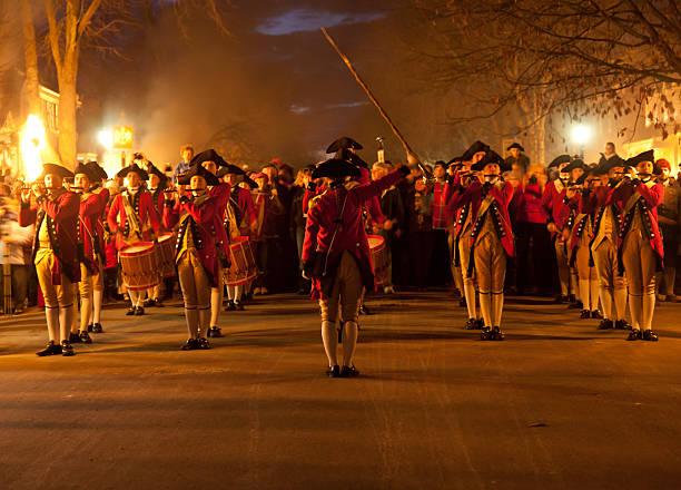 Marching soldiers in Colonial Williamsburg "Williamsburg, VA, USA - December 29, 2011: Red-coated fife and drum corps take part in the Illumination of the Taverns parade in Colonial Williamsburg. The Grand Illumination takes place on the first Sunday in December." williamsburg virginia stock pictures, royalty-free photos & images