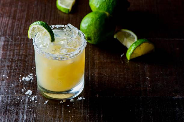 Margarita. Classic traditional Mexican cocktail. Made with Blanco tequila, fresh lime juice, agave syrup and orange juice. Served in salt rimmed tumbler over ice and garnished with a lime. stock photo