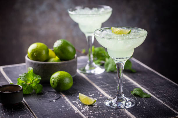 margarita cocktail with lime margarita cocktail with lime in a glass on dark background garnish stock pictures, royalty-free photos & images