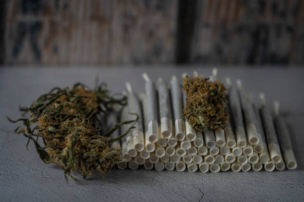 Marijuana joints on whte concrete floor with wooden background stock photo