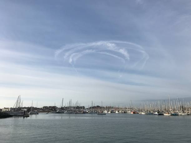 Marina sailing boats with vapor trails in blue sky stock photo