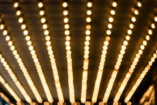 Rows of illuminated globes under the marquee as often used at entrance to theatres and casinos