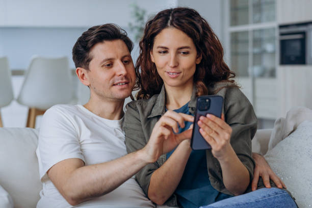 Married woman and man smile happily reading good news stock photo