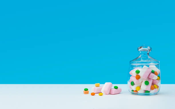 Marshmallow with dragee next to the glass transparent jar and in it Marshmallow with dragee next to the glass transparent jar and in it candy jar stock pictures, royalty-free photos & images