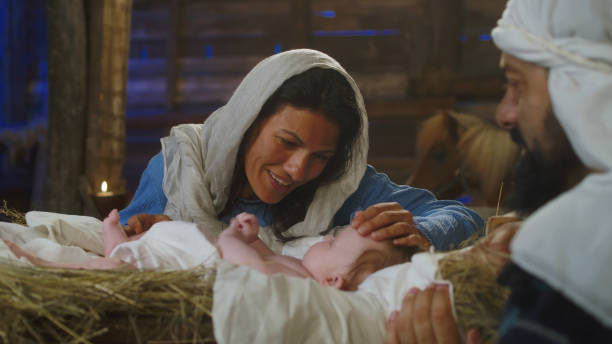 Mary talking with baby Jesus near Joseph stock photo