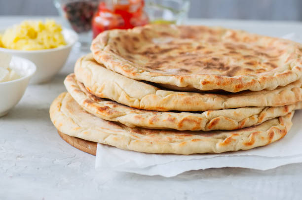 Mashed potato and sheep cheese filling flatbread on a white stone background. Mashed potato and sheep cheese filling flatbread on a white stone background. naan bread stock pictures, royalty-free photos & images