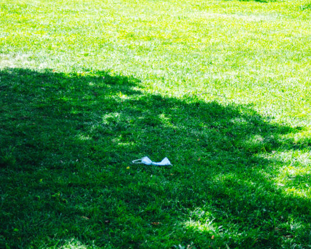 Mask left on the green grass. Awareness stock photo