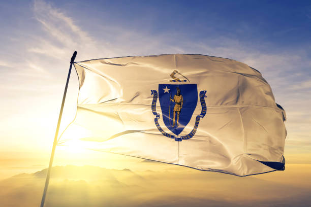 Massachusetts state of United States flag textile cloth fabric waving on the top sunrise mist fog Massachusetts state of United States flag on flagpole textile cloth fabric waving on the top sunrise mist fog massachusetts stock pictures, royalty-free photos & images