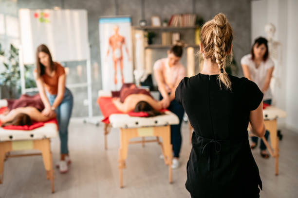 Massage therapist instructor showing practice to students Women in massage school learning to be massage therapists anatomy photos stock pictures, royalty-free photos & images