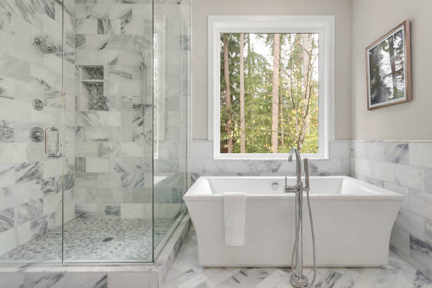 master bagno interno in casa di lusso con grande doccia con piastrelle eleganti e vasca da bagno. include grande finestra con vista sugli alberi. - bagno foto e immagini stock