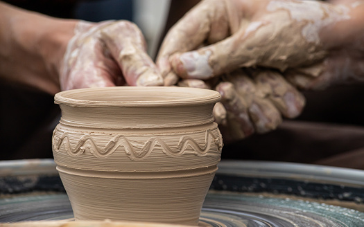 Master class on modeling of clay on a potter's wheel In the pottery workshop.