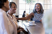 istock Mature adult female friends laugh when they meet at cafe 1176649312