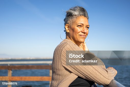 istock Mature black woman relaxing at the pier 1316488076