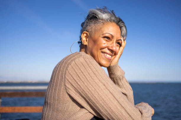 Mature black woman relaxing at the pier stock photo
