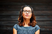 Portrait of mature businesswoman standing against a wooden wall in office
