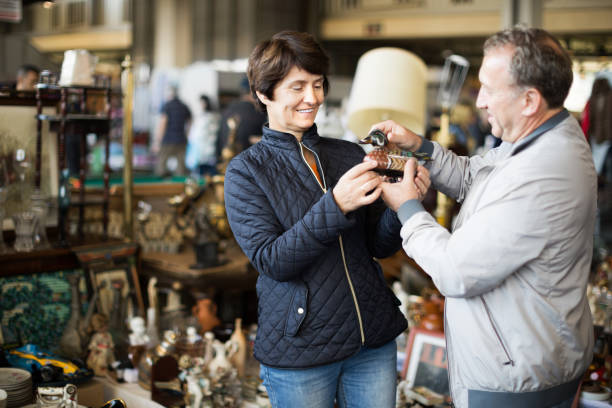 Mature couple buying antique things at the fleamarket Mature family couple buying antique things at the fleamarket outdoor flea market photos stock pictures, royalty-free photos & images