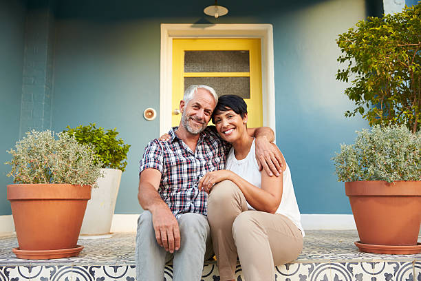 Mature Couple Sitting On Steps Outside House Mature Couple Sitting On Steps Outside House mature couple stock pictures, royalty-free photos & images