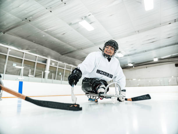 Mature Disabled Latin woman playing sledge hockey stock photo